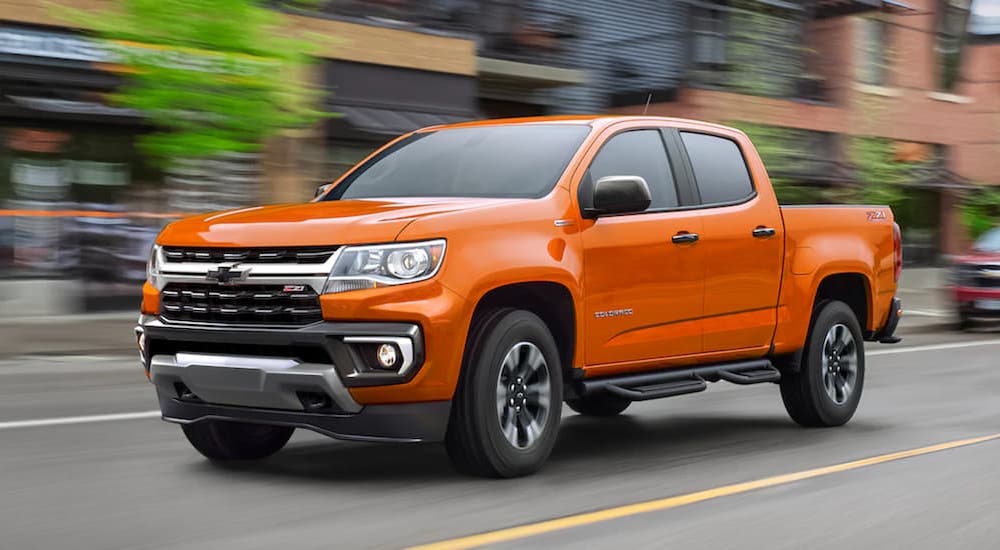 An orange 2022 Chevy Colorado is shown from the front at an angle on a city street.