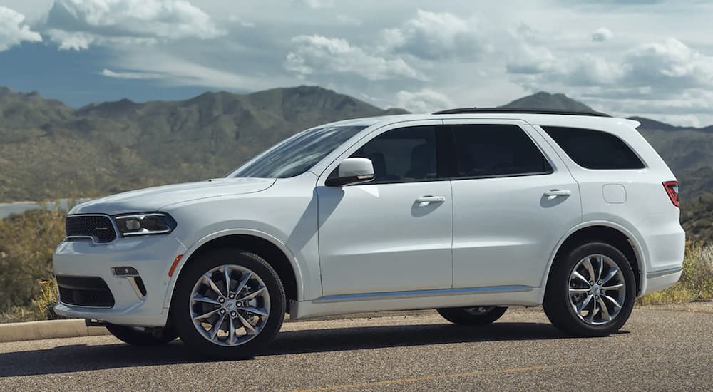 A white 2022 Dodge Durango is shown from the side parked in front of a mountain range.