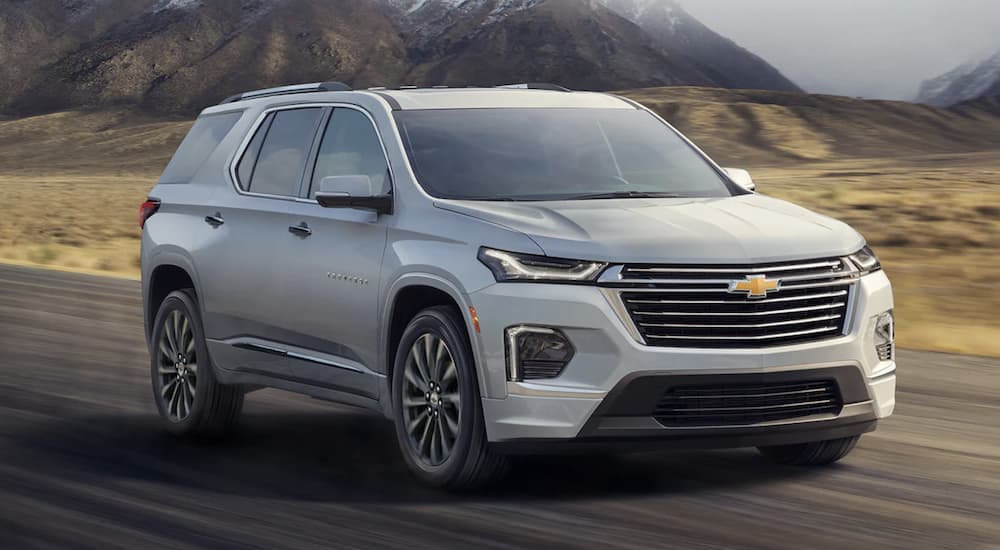 A silver 2022 Chevy Traverse is shown from the front driving on an open road during a 2022 Chevy Traverse vs 2022 Dodge Durango comparison.