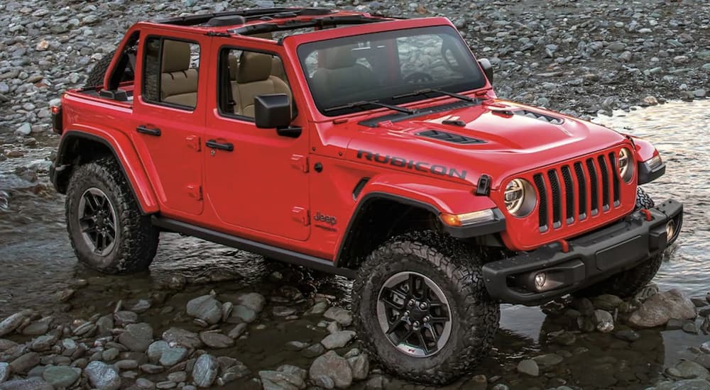 A red 2022 Jeep Wrangler is shown parked at an angle in the mountains.