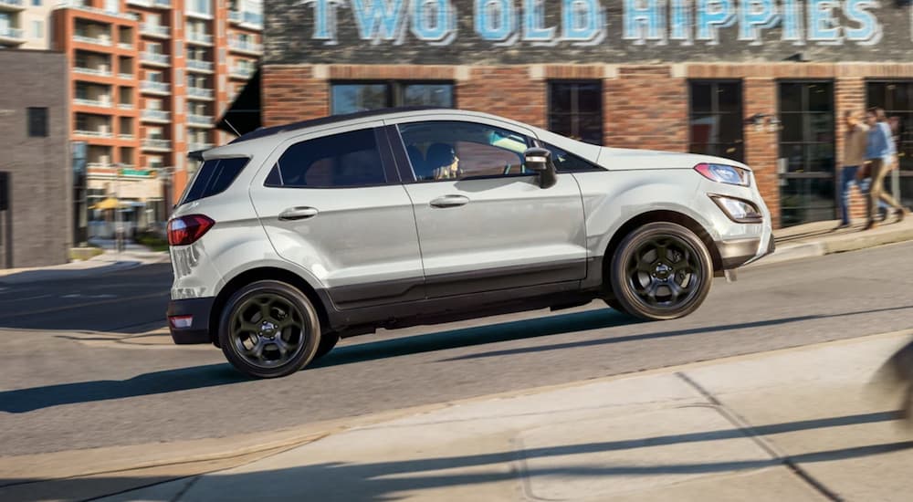 A white 2022 Ford EcoSport is shown from the side driving up a city hill.