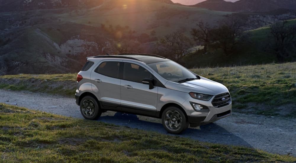 A silver 2022 Ford EcoSport is shown off-roading at sunset.