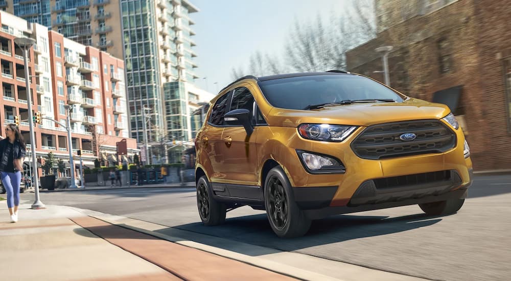 A gold 2022 Ford EcoSport is shown speeding down a city street.