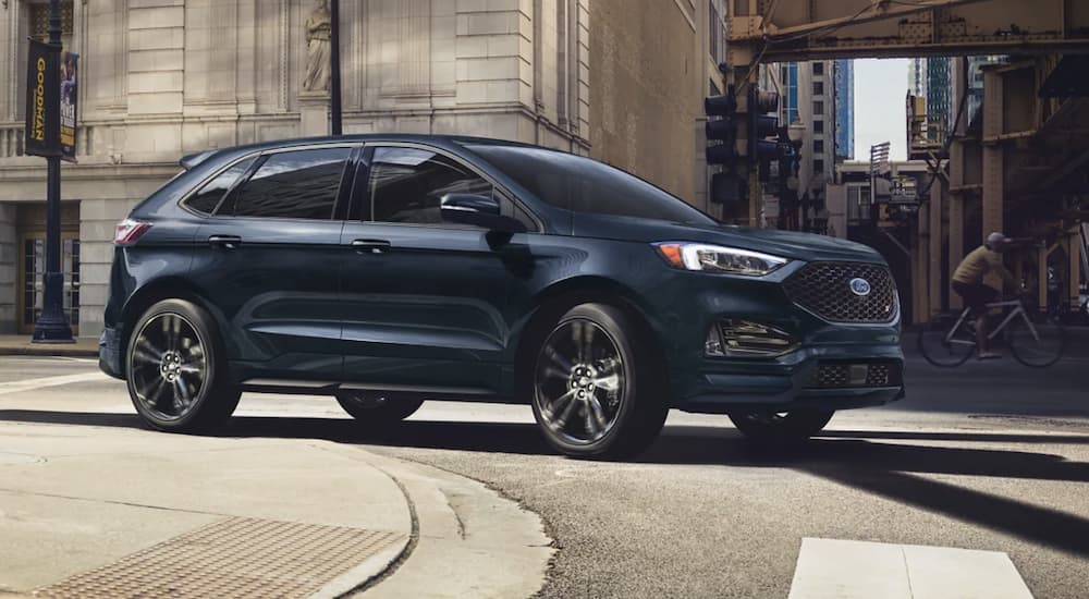 A blue 2022 Ford Edge is shown from the side rounding a city corner after leaving a 2022 Ford Edge dealer.