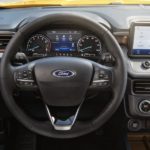 The black interior of a 2022 Ford Maverick shows the steering wheel and infotainment screen.