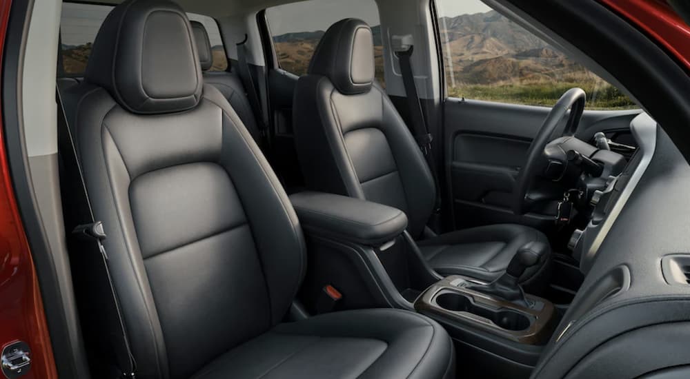 The black interior of a 2022 GMC Canyon shows the front seats.