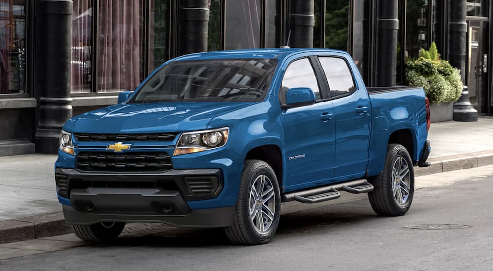 A blue 2022 Chevy Colorado is shown from the front parked on a city street. 