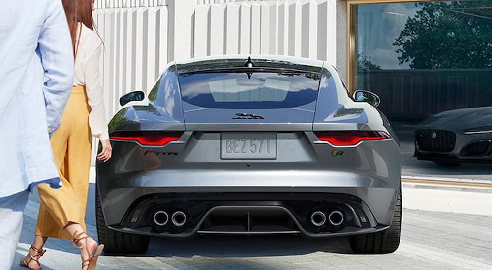 A grey 2022 Jaguar F-Type is shown from the rear on a city street.