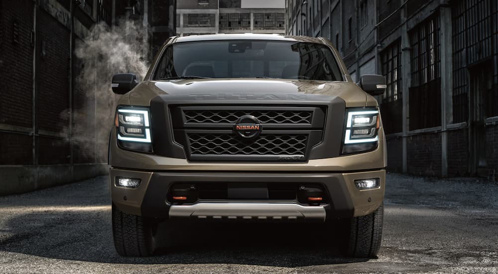 A brown 2022 Nissan Titan is shown from the front parked in an alleyway.