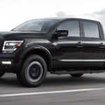 A black 2022 Nissan Titan is shown from the side driving on a highway.