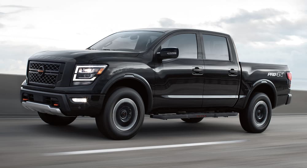 A black 2022 Nissan Titan is shown from the side driving on a highway.