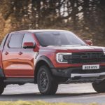 A red 2022 Ford Ranger Raptor is shown from the front at an angle.