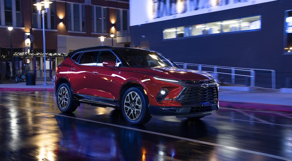A red 2023 Chevy Blazer RS is shown from the front while driving through a city at night after leaving a Rancho Cordova Chevy dealer.