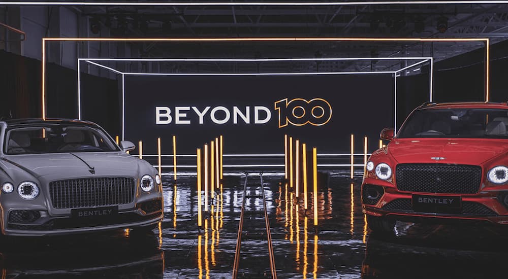 A grey and red Bentley are shown at the Beyond100 presentation.