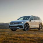 A white 2022 Volkswagen Tiguan is shown parked in an open field.