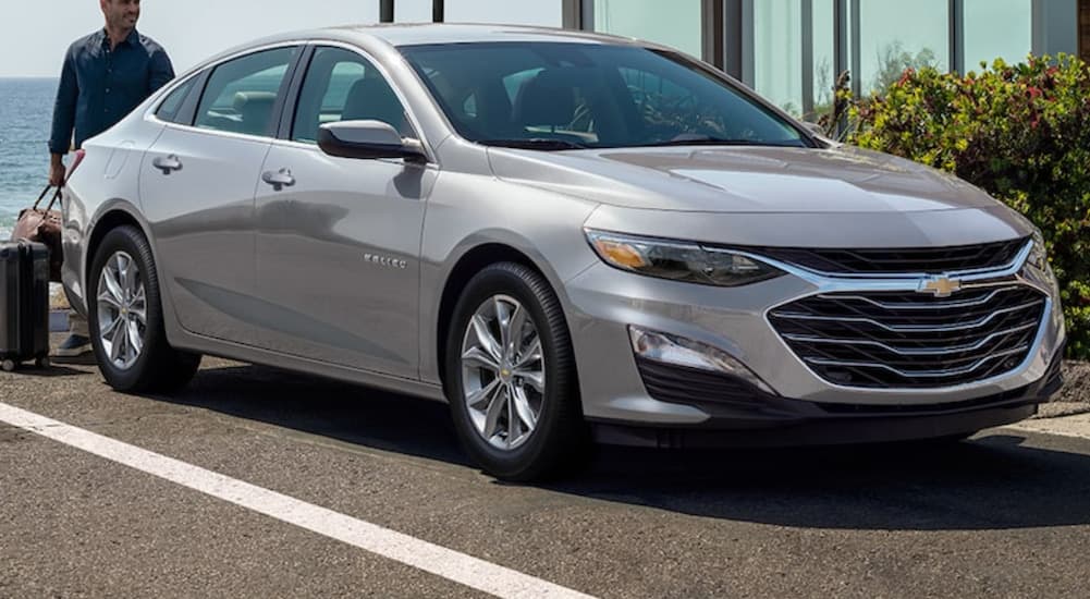 A silver 2021 Chevy Malibu is shown parked in a spot.