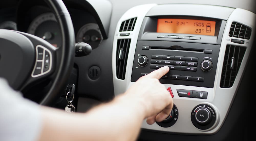 Someone is pointing to the infotainment screen after deciding to 'sell my car.'