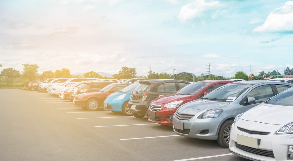 Cars are shown in a sunny parking lot.