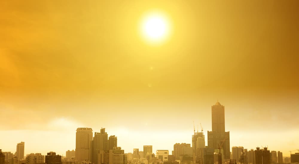 The sun is shown over a city.