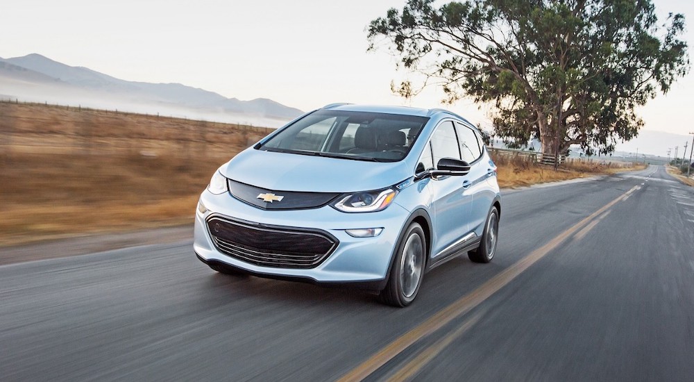 A blue 2017 Chevy Bolt EV is shown from the front at an angle after leaving a Suwanee Chevy dealership.