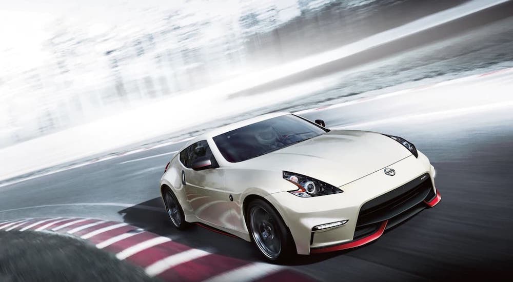 A white 2020 Nissan 370z Nismo is shown from the front at an angle on a racetrack.