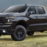 A black 2022 Chevy Silverado Limited is shown parked in a field during a 2022 Chevy Silverado 1500 Limited vs 2022 Chevy Silverado 1500 comparison.