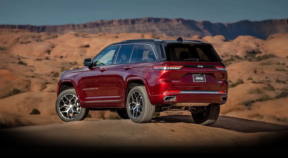 A red 2022 Jeep Grand Cherokee WL is shown from the rear off-road.