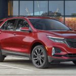 A red 2022 Chevy Equinox RS is shown from the side parked in front of a building.