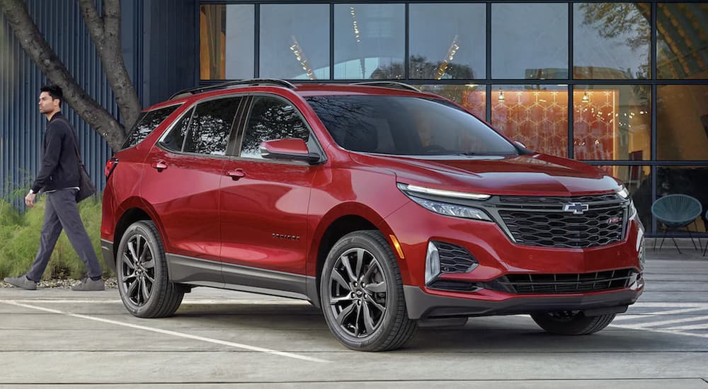 A red 2022 Chevy Equinox RS is shown from the side parked in front of a building.