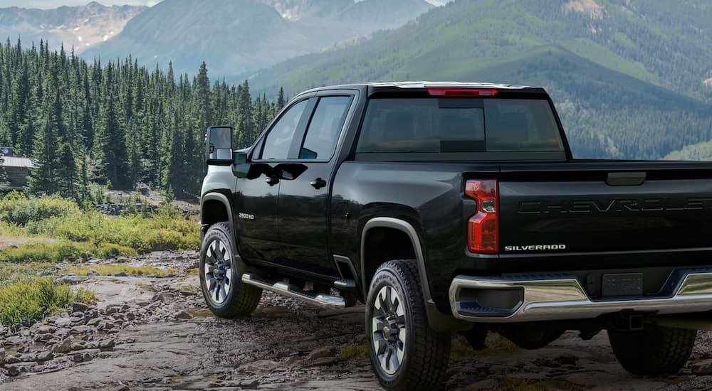 A black 2022 Chevy Silverado 2500HD Custom is shown from the rear overlooking a mountain view.