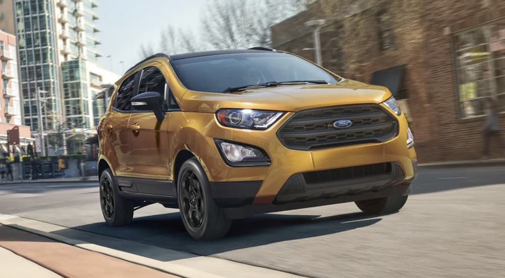 A gold 2022 Ford EcoSport is shown from the front driving on an open road during a 2022 Ford EcoSport vs 2022 Hyundai Venue comparison.
