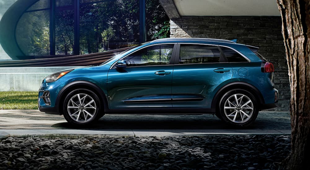 A blue 2022 Kia Niro is shown from the side while parked in a driveway.