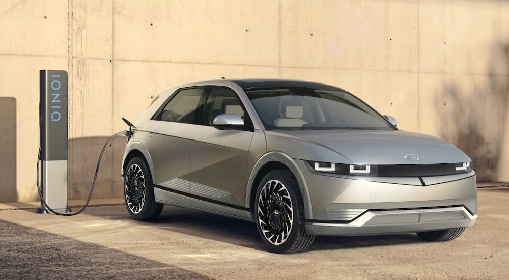 A silver 2023 Hyundai Ioniq 5 is shown from the front at a charger after the owner searched for 'Hyundai dealership Alberta'.