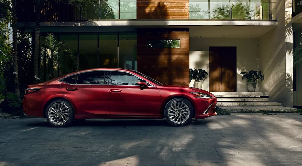 A red 2022 Lexus ES Hybrid is shown from the side parked in a driveway.