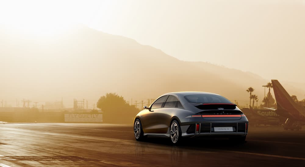 A grey 2024 Hyundai Ioniq 6 is shown from the rear at an angle on an airstrip.