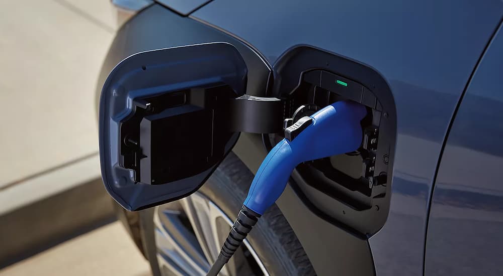 A close up of a 2023 Subaru Solterra is shown charging at a Subaru Solterra dealership.