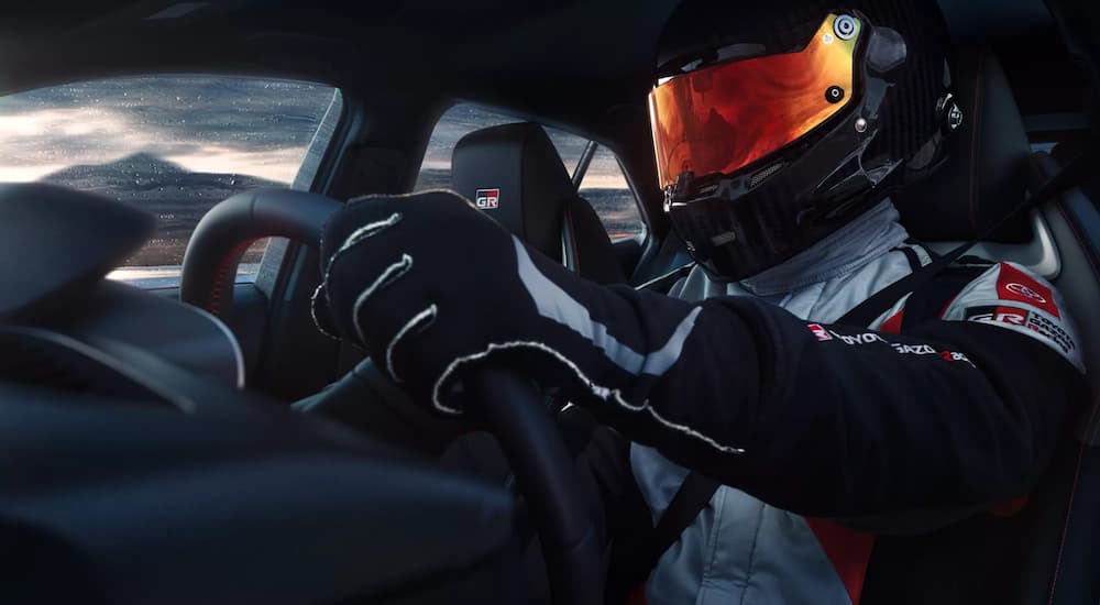 A race car driver is shown in a 2023 Toyota GR Corolla.