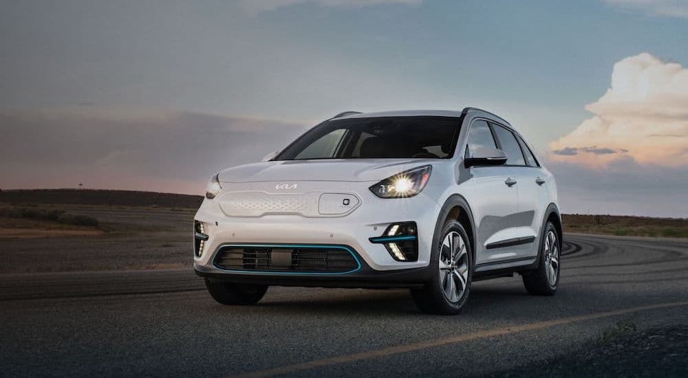 A white 2022 Kia Niro Ev is shown from the front at an angle after the owner searched 'Kia dealership'.