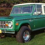 A green 1971 Ford Bronco is shown from the front at an angle.