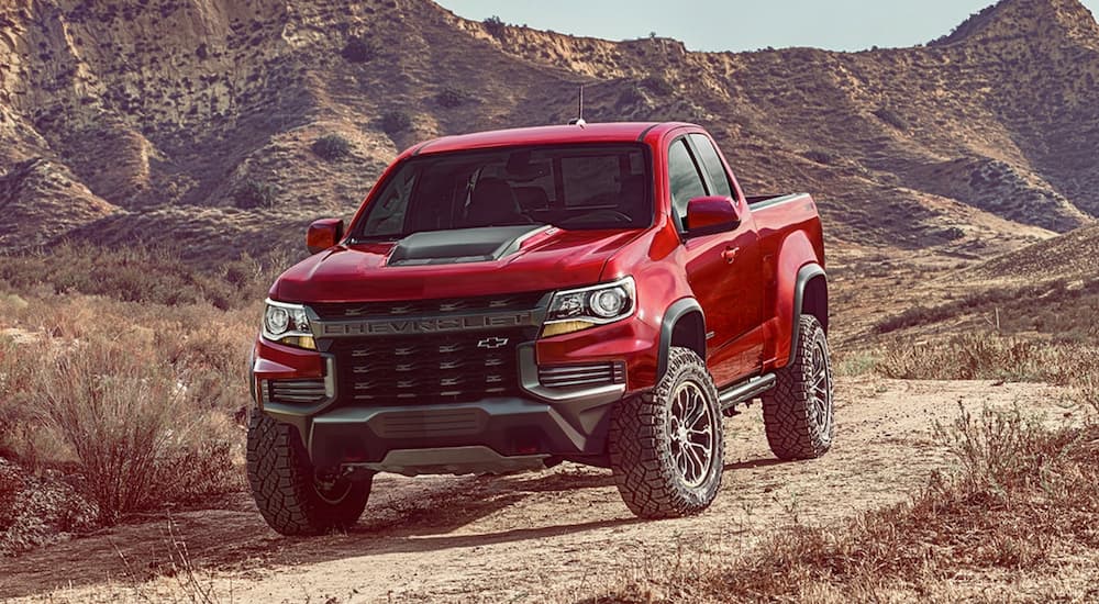 A red 2021 Chevy Colorado ZR2 is shown from the front while parked off-road.