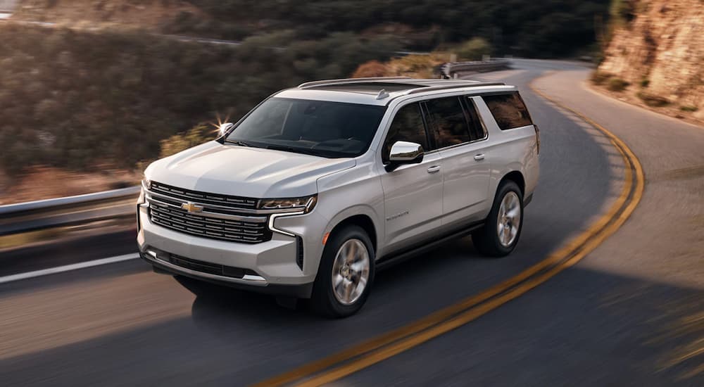 A white 2023 Chevy Suburban is shown from the front at an angle.