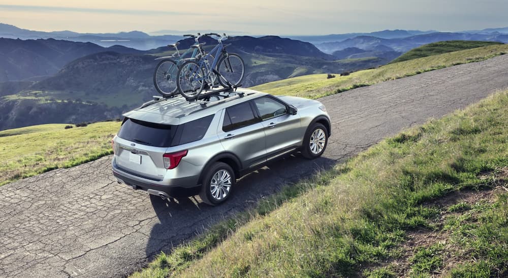 A silver 2022 Ford Explorer is shown from the rear at an angle on a dirt trail.