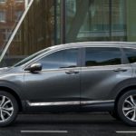 A grey 2022 Honda CR-V Hybrid Touring is shown from the side parked in front of a city building.