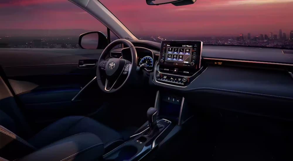 The interior of a 2023 Toyota Corolla Cross Hybrid is shown from the passenger seat.
