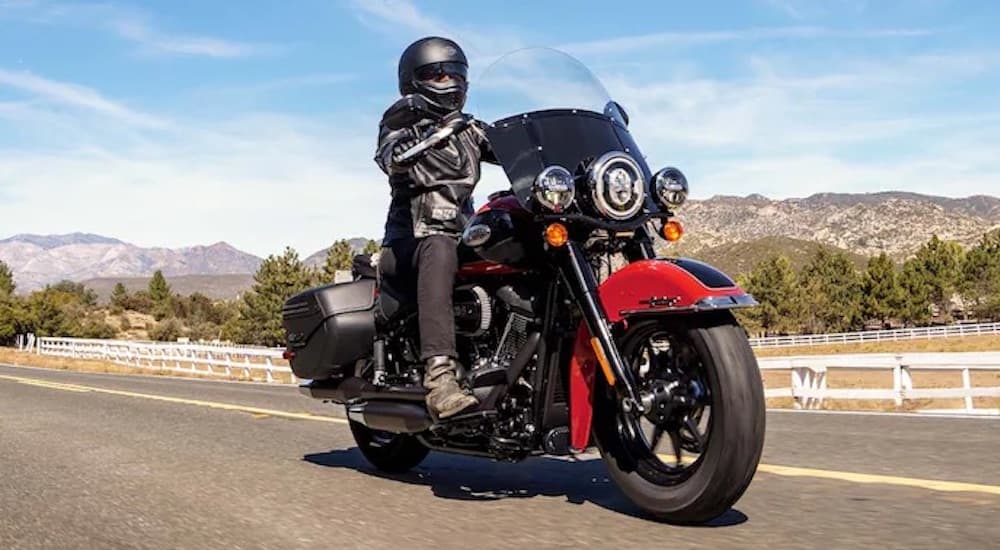 A red and black 2022 Harley-Davidson Heritage Classic 114 is shown from the front on a desert highway.