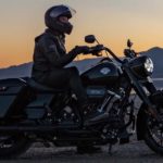 A rider is shown sitting on a black 2022 Harley-Davidson Road King Special at sunset.