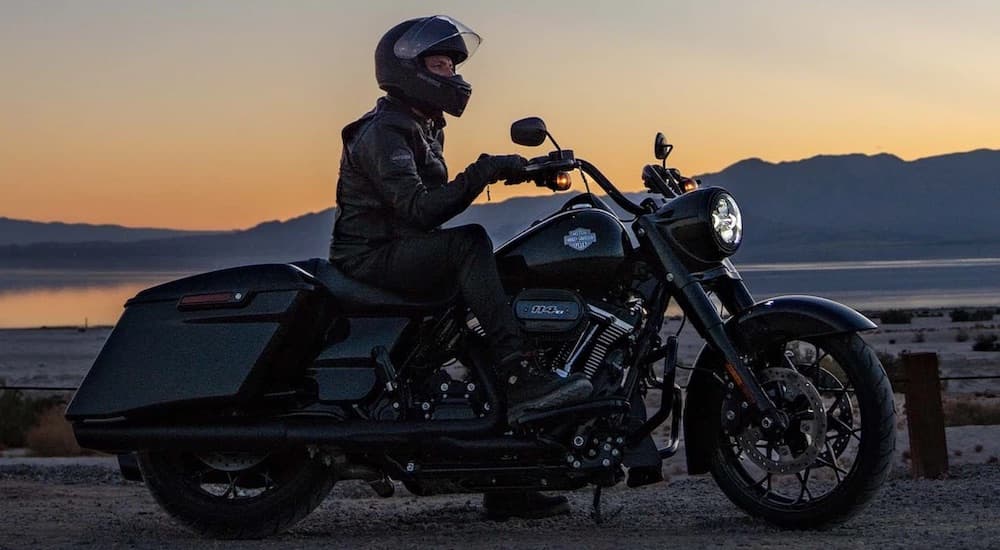 A rider is shown sitting on a black 2022 Harley-Davidson Road King Special at sunset.