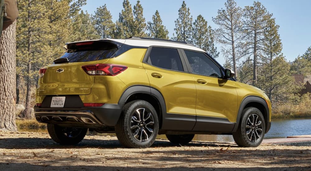 A yellow 2023 Chevy Trailblazer ACTIV is shown from the rear parked in front of a lake.