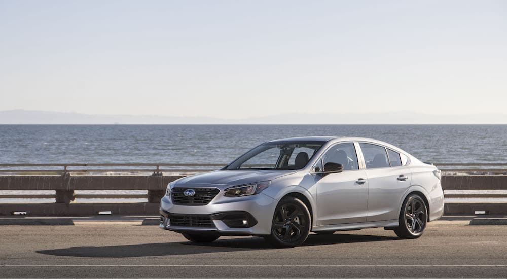 A silver 2022 Subaru Legacy Sport is shown from the front at an angle while parked on a coastal road.