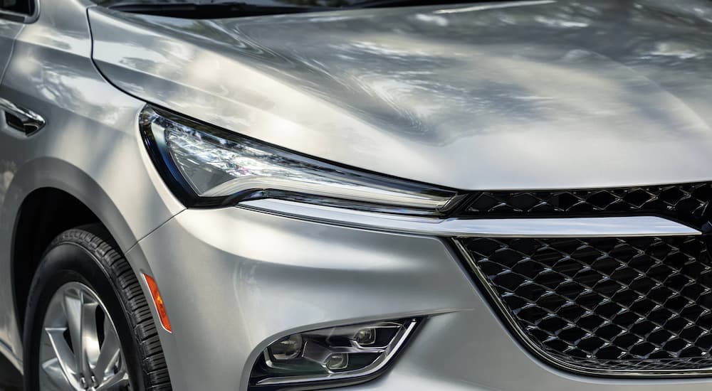 A close up of the headlight and grille on a silver 2022 Buick Enclave Avenir is shown.